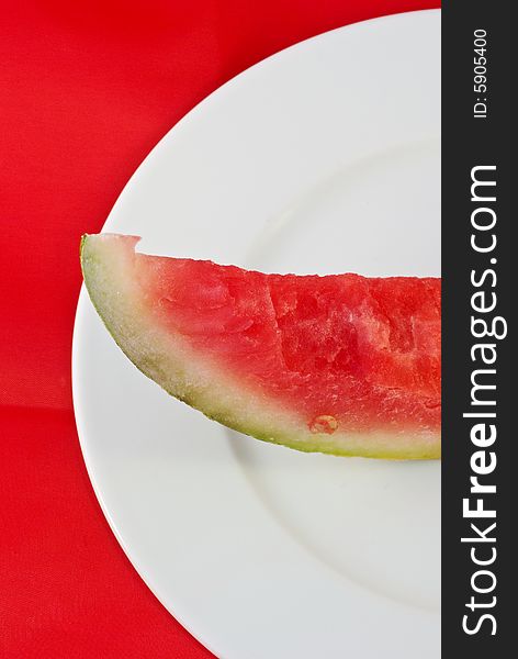 A plate with a peiece of watermelon in a graphical composition. A plate with a peiece of watermelon in a graphical composition