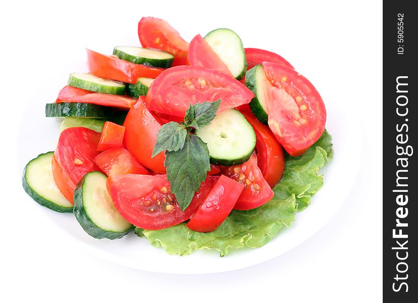 Tomatos and cucumbers and salad on a white background