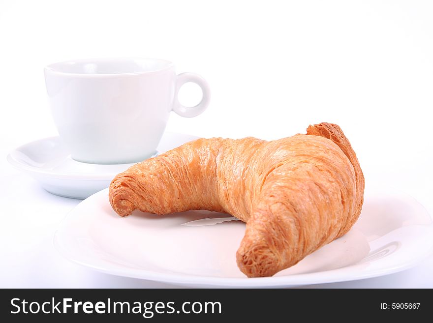 White cup and croissant isolated on white. White cup and croissant isolated on white