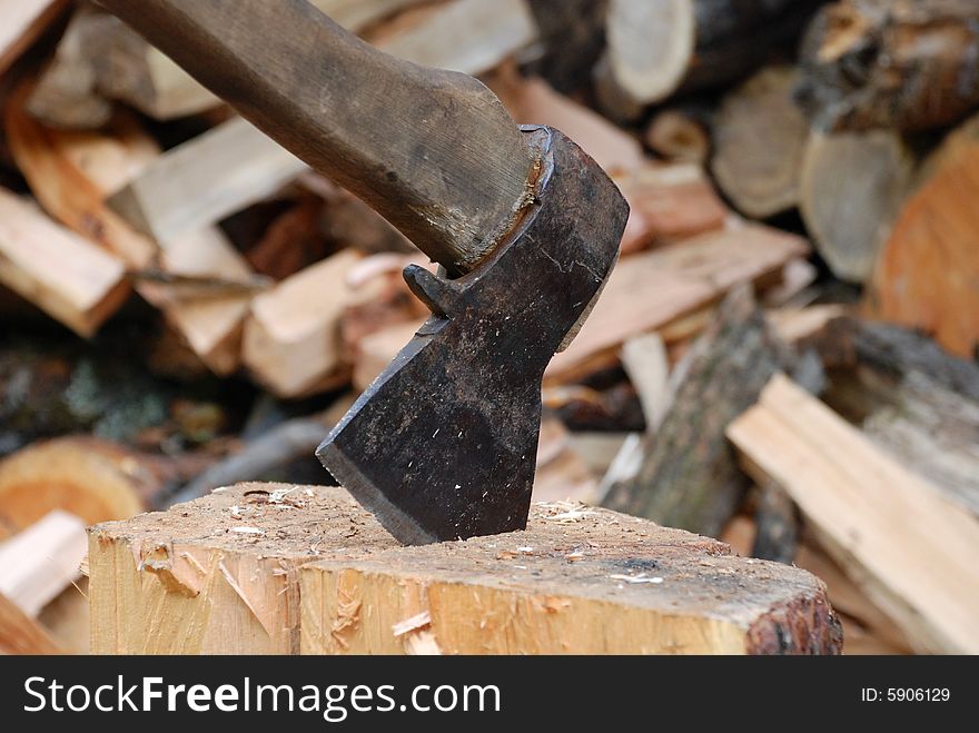 Old axe and firewoods on the background