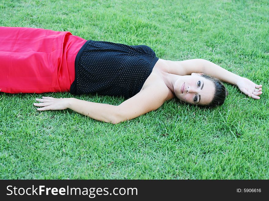 Beautiful brunette relaxing on the green grass. Beautiful brunette relaxing on the green grass.