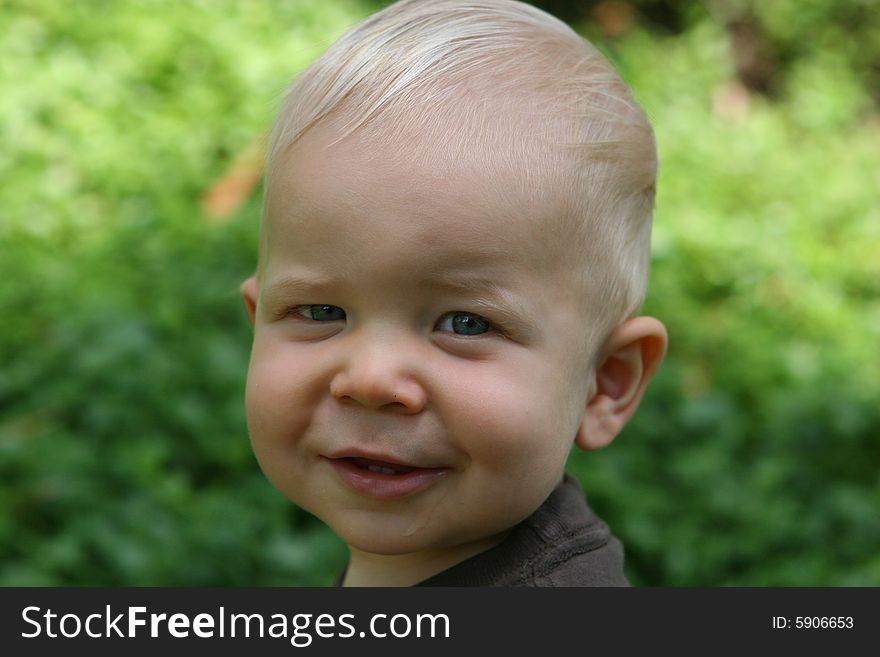 Child toddler has head shot with blond hair is smiling. Child toddler has head shot with blond hair is smiling.