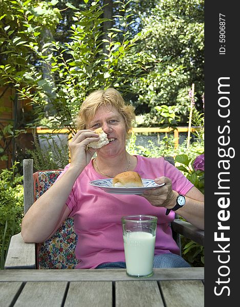 Elderly woman is eating lunch in the garden