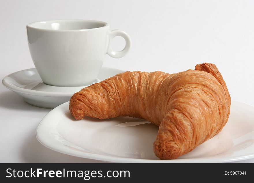 White cup and croissant isolated on white. White cup and croissant isolated on white