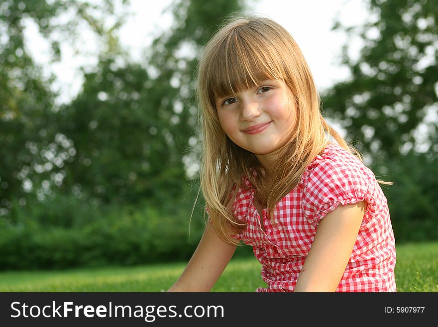 Cute little girl smiling outdoors on summer day
