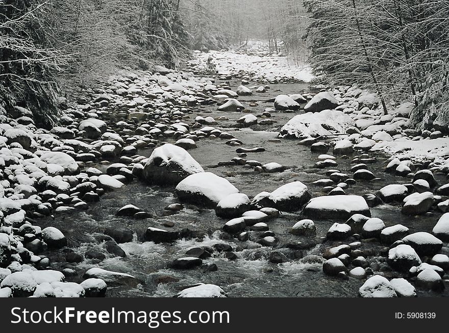 Snow covered rocks in a creek. Snow covered rocks in a creek