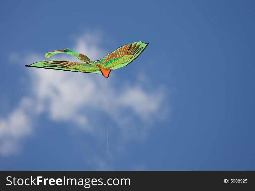 Green kite flying in the blue sky. Green kite flying in the blue sky