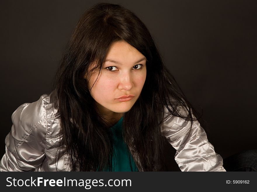 Beautiful girl in silver jacket isolated on black background