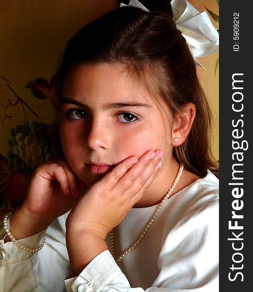 Closeup of school aged girl with solemn expression and hand on cheek. Closeup of school aged girl with solemn expression and hand on cheek