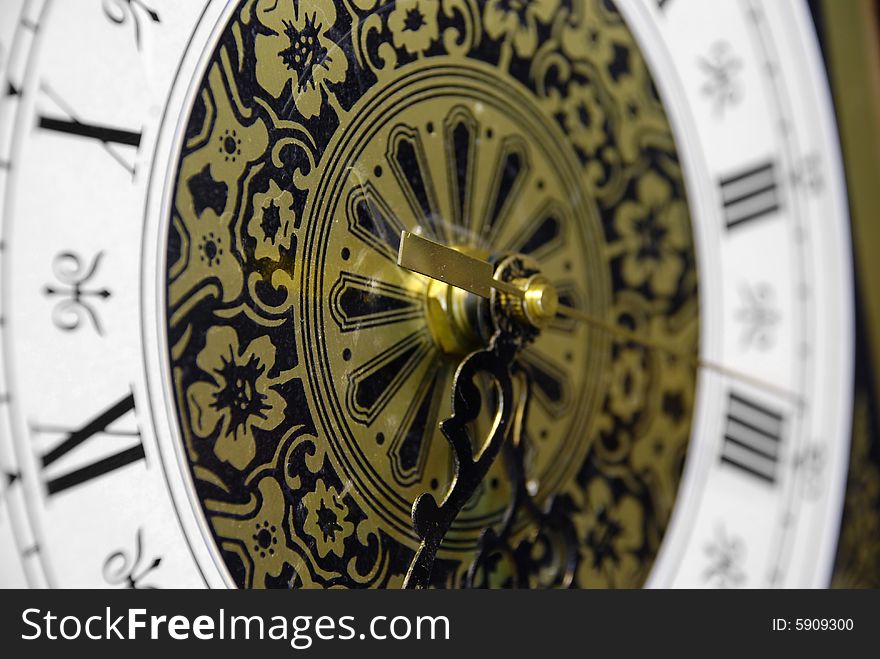 Tight crop of a gold, black and white colored antique clock.