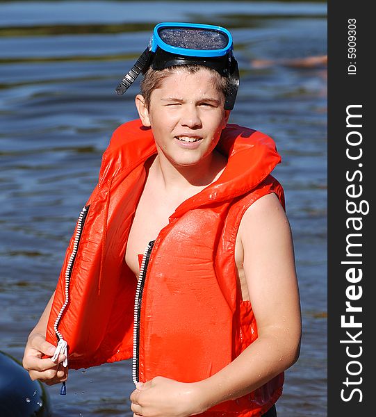 The portrait of the boy with a life-jacket and a diving mask. The portrait of the boy with a life-jacket and a diving mask.