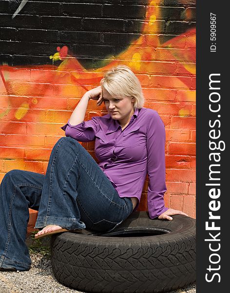 Portrait of a girl sitting on tire. Portrait of a girl sitting on tire.