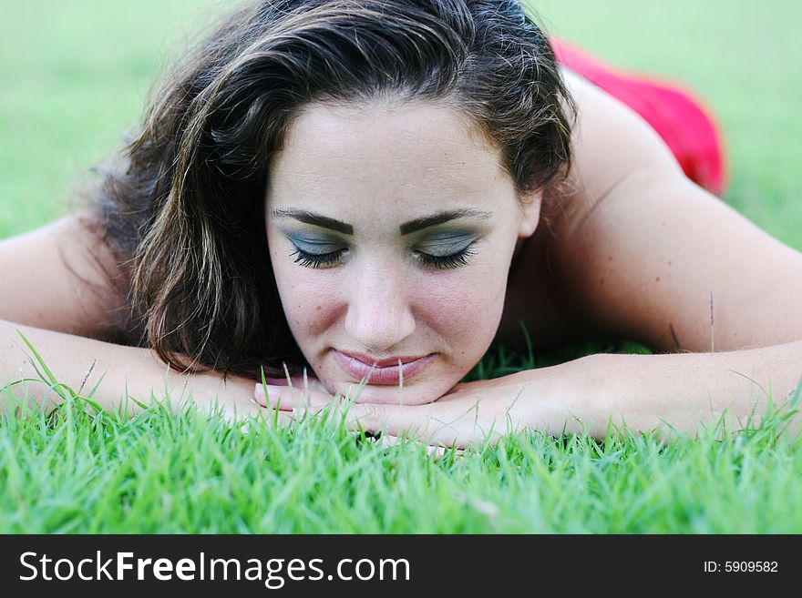 Close-up portrait of a woman relaxing outside with her eyes closed.