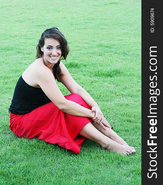 Portrait of a beautiful woman sitting on the grass.