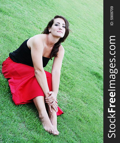 Portrait of a beautiful woman sitting on the grass.