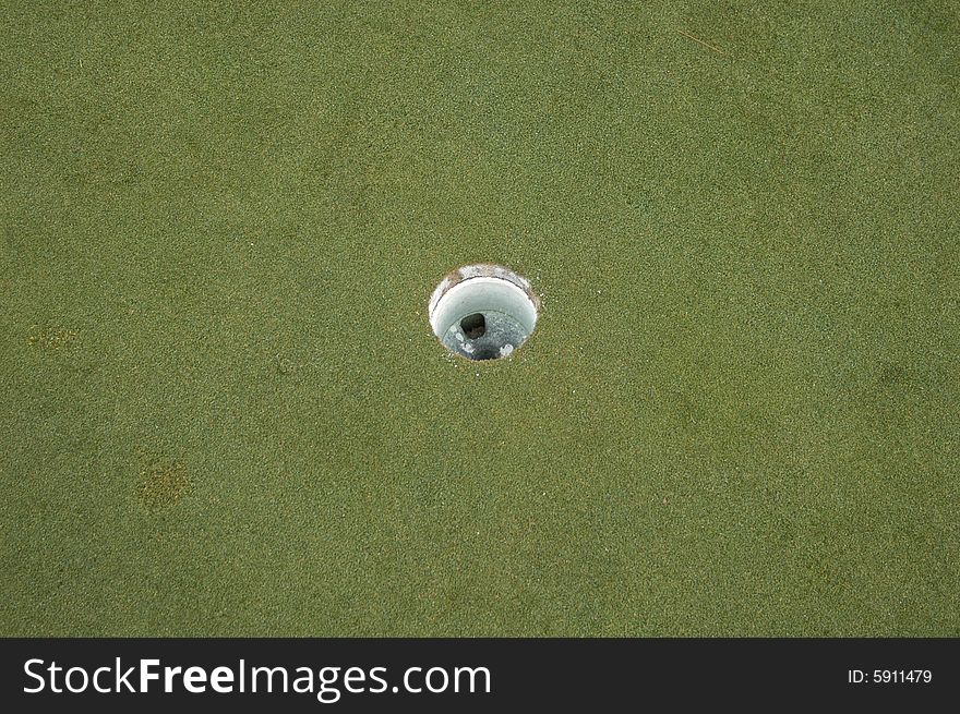 The round hole on a golf course green. The round hole on a golf course green