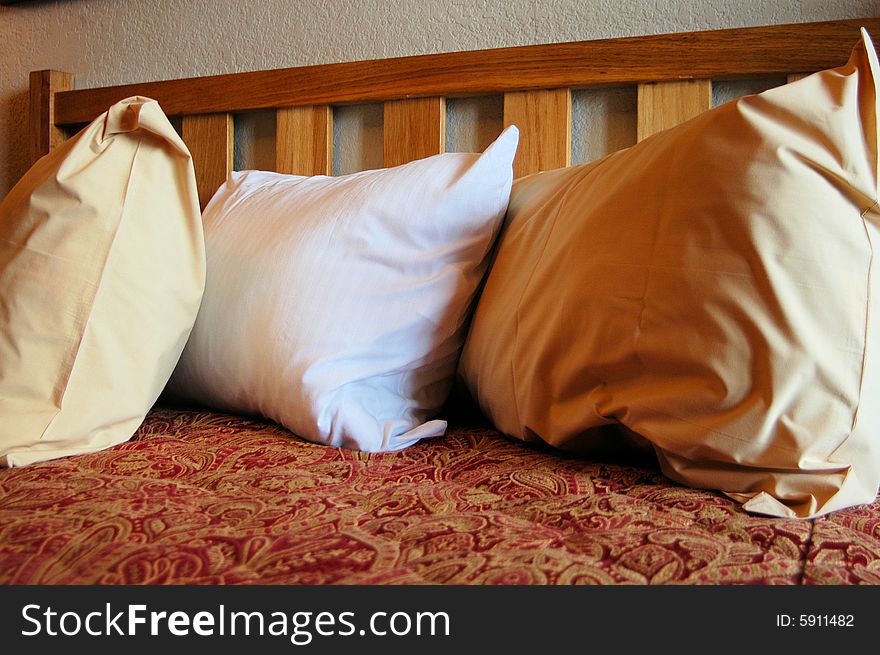 Three pillows on a bed in a hotel room. Three pillows on a bed in a hotel room