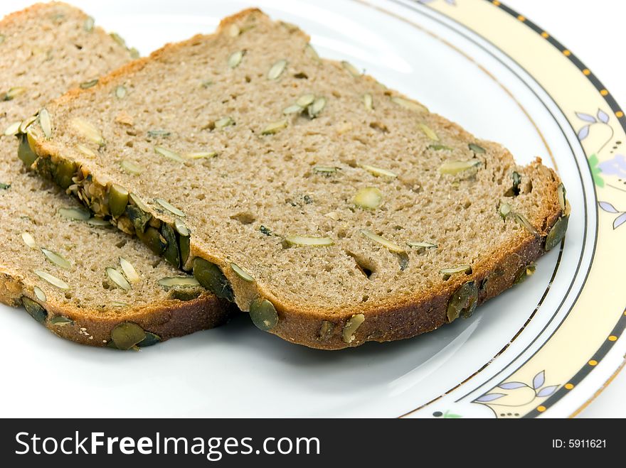 Wholegrain bread with sunflower seeds on white background.