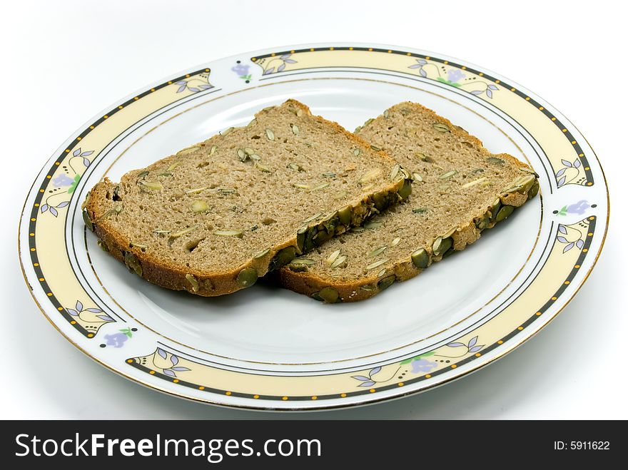 Wholegrain bread with sunflower seeds on white background.