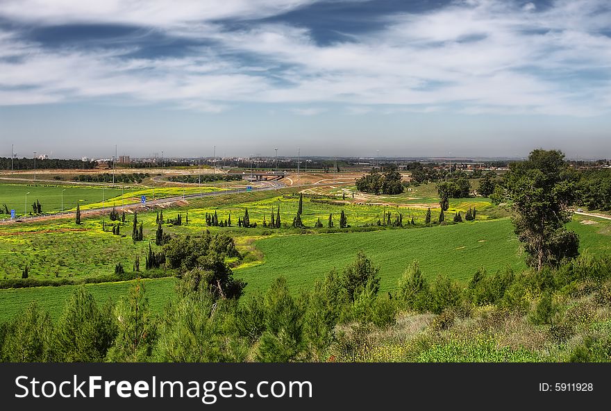 View on green fields and blue sky with clouds at spring time in Israel. View on green fields and blue sky with clouds at spring time in Israel.