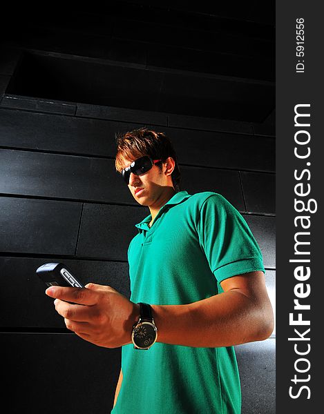 Picture of a male model with technology related activities and a dark background. Use for illustrating contexts of IT, suaveness or computer crimes. Picture of a male model with technology related activities and a dark background. Use for illustrating contexts of IT, suaveness or computer crimes.