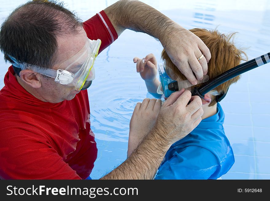 Father Adjusting His Son S Snorkel And Mask