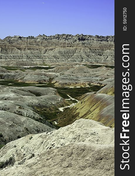 Colorful Badland mountains separated by green grass and dry river beds in South Dakota, USA. Colorful Badland mountains separated by green grass and dry river beds in South Dakota, USA