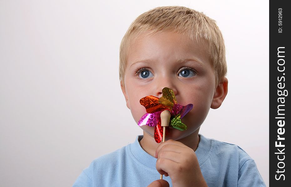 Toddler playing with a wind toy made of bright colors. Toddler playing with a wind toy made of bright colors