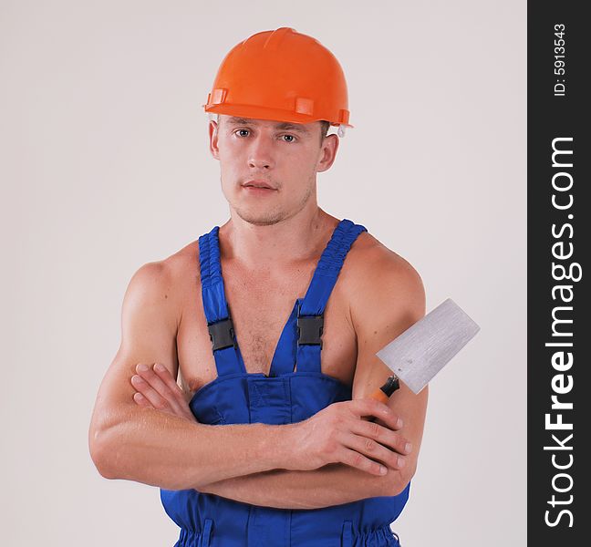 Worker in blue uniform and helmet with trowel. Worker in blue uniform and helmet with trowel