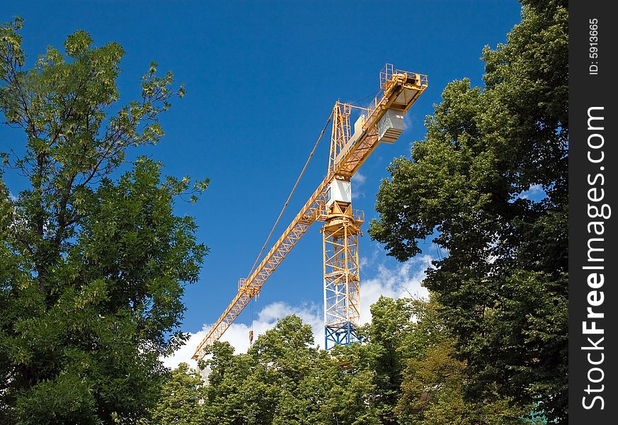 The building crane on a background of the blue sky. The building crane on a background of the blue sky