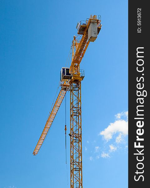 The building crane on a background of the blue sky. The building crane on a background of the blue sky