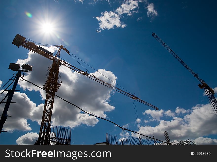 The building crane on a background of the blue sky. The building crane on a background of the blue sky