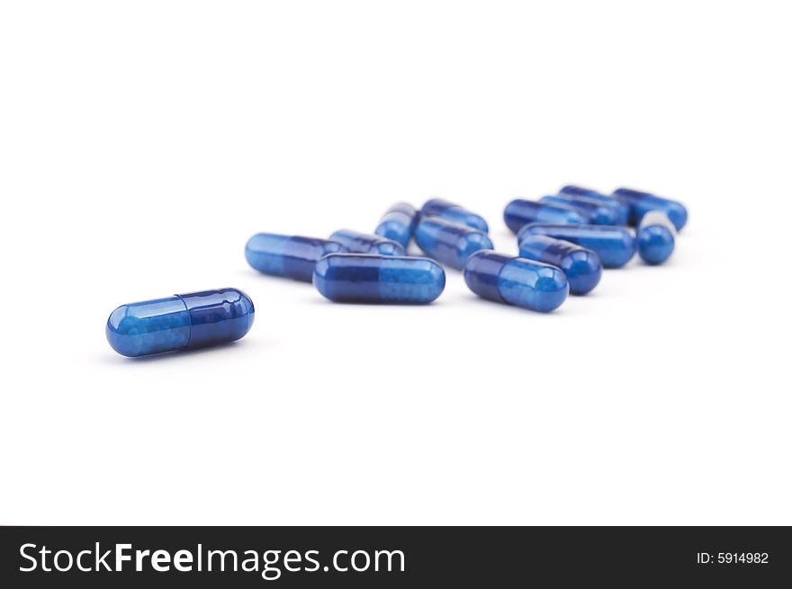 Group of blue pills isolated on white background. Shallow depth of focus
