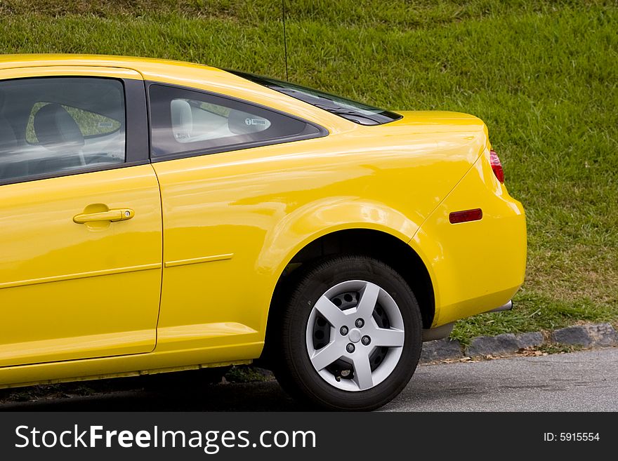 Rear end of a small bright yellow car. Rear end of a small bright yellow car