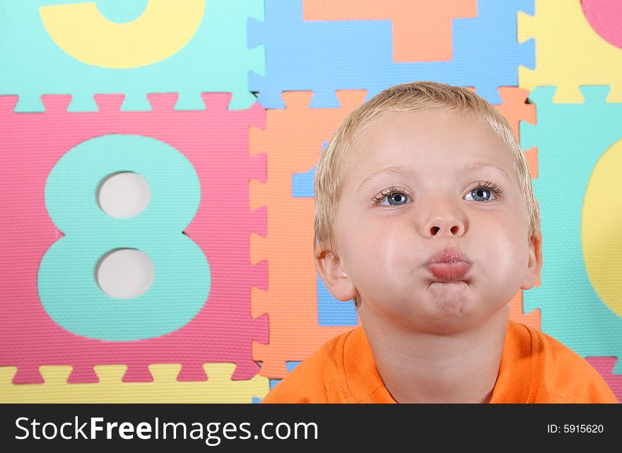 Blond Toddler playing against a colorful background. Blond Toddler playing against a colorful background