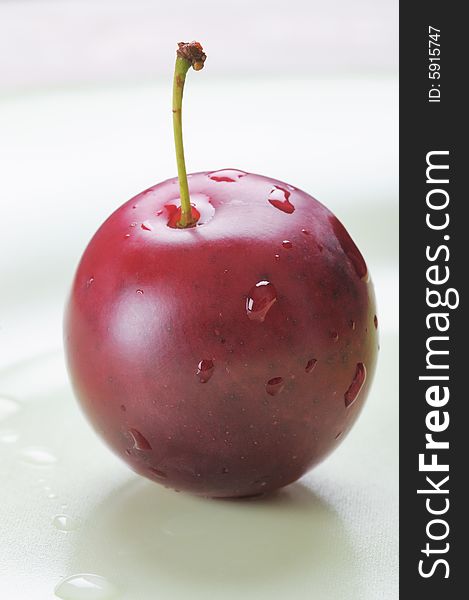 Red cherry-plum on the plate. Narrow depth of field. Red cherry-plum on the plate. Narrow depth of field.