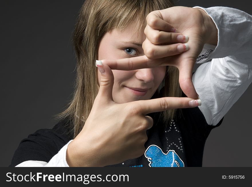 Teenage girl folds palms in frame box. Teenage girl folds palms in frame box