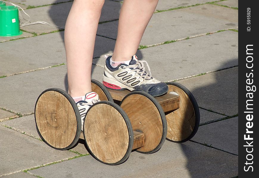 The boy goes for a drive on asphalt on old wooden rollers