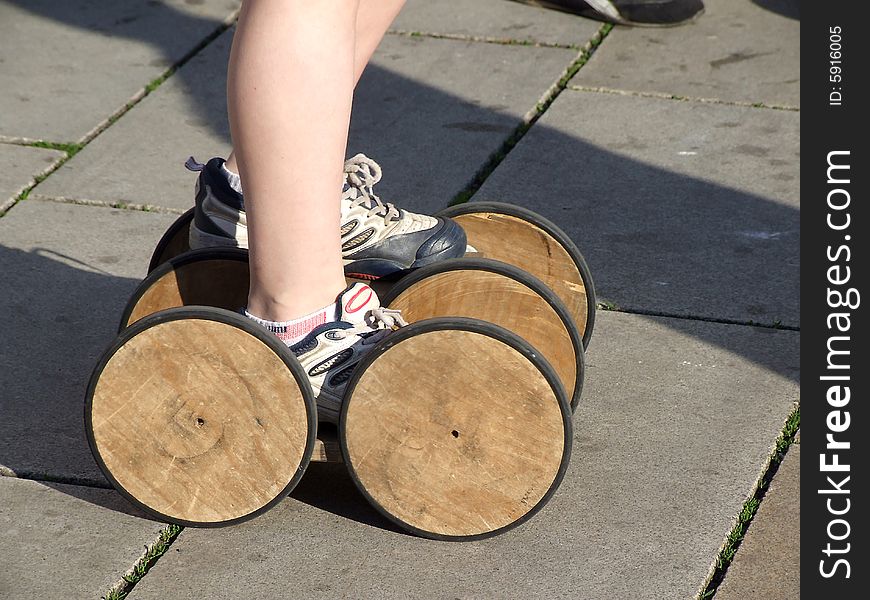 The boy goes for a drive on asphalt on old wooden rollers