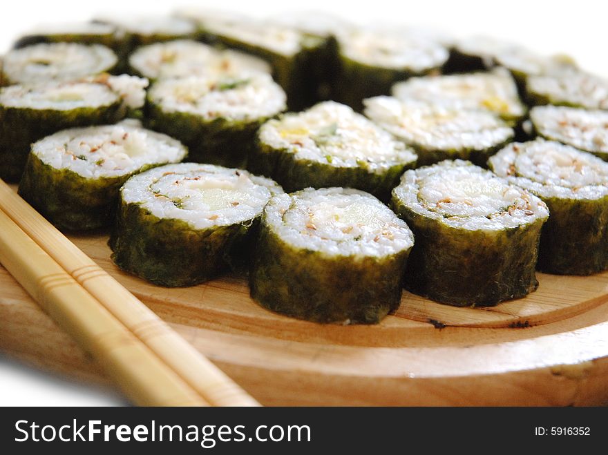 Maki sushi rolls arranged on a plate with chopsticks