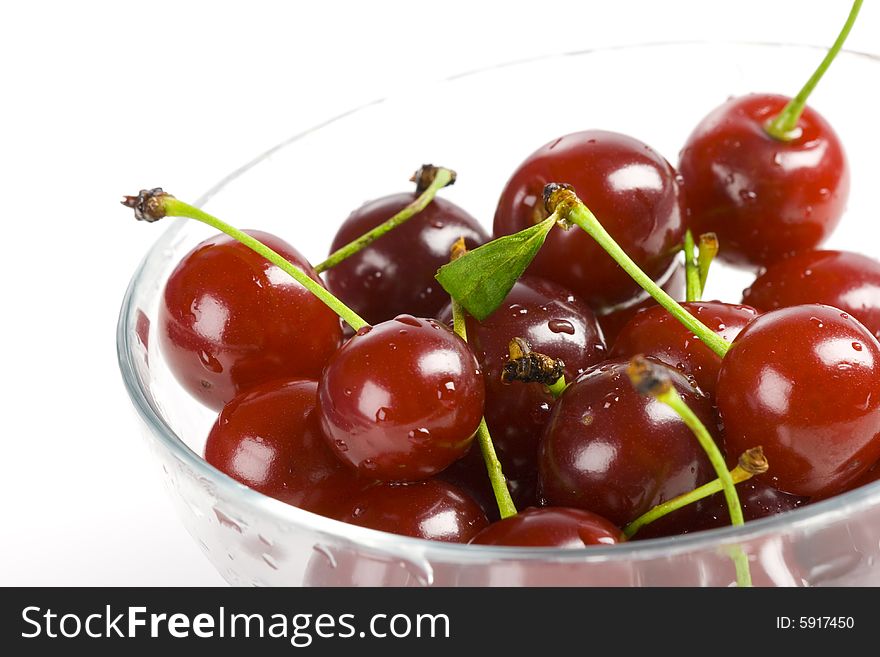 Red cherries are in a white bowl. Red cherries are in a white bowl