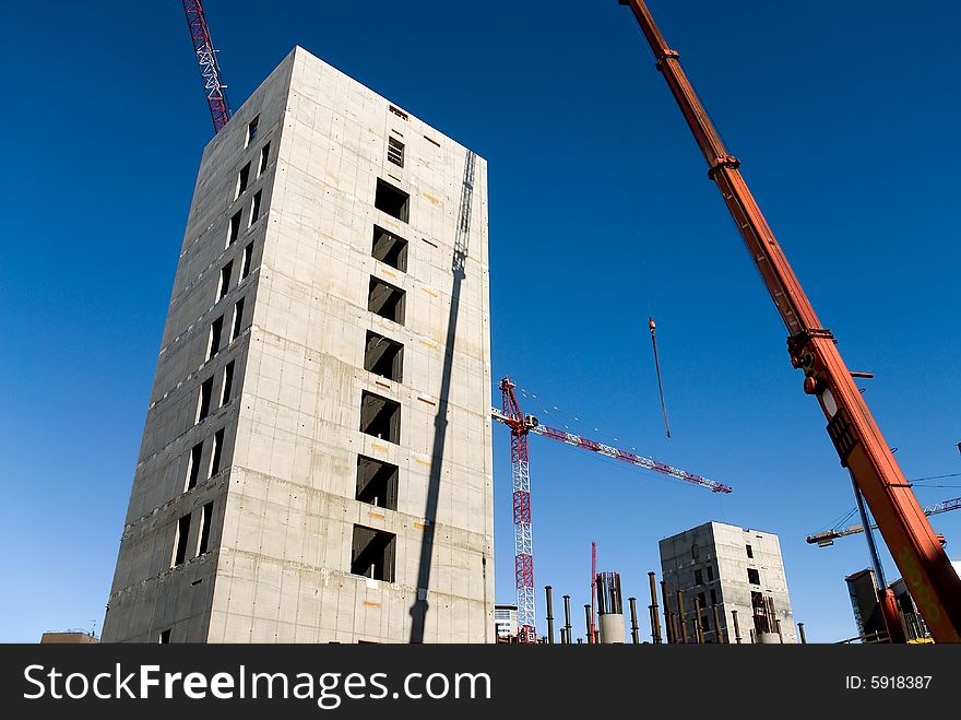 Concrete structure and cranes against a limpid sky. Concrete structure and cranes against a limpid sky