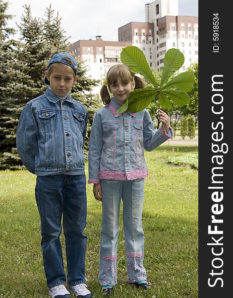 The boy and the girl play with leaves