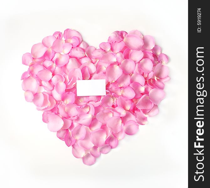 Pink rose petals forming a heart with blank card - isolated. Pink rose petals forming a heart with blank card - isolated