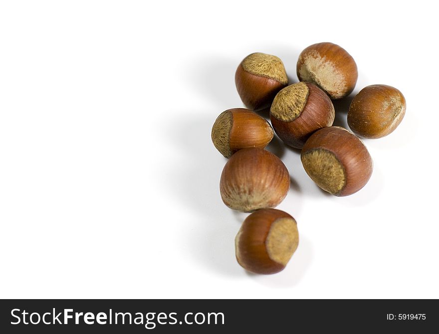 Some hazelnuts on white background