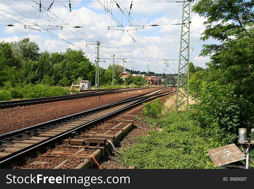 Empty railway tracks with electrical wiring.