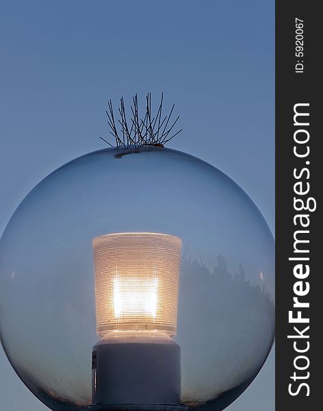 Large glass ball on outdoor lamp with bird spikes. Large glass ball on outdoor lamp with bird spikes