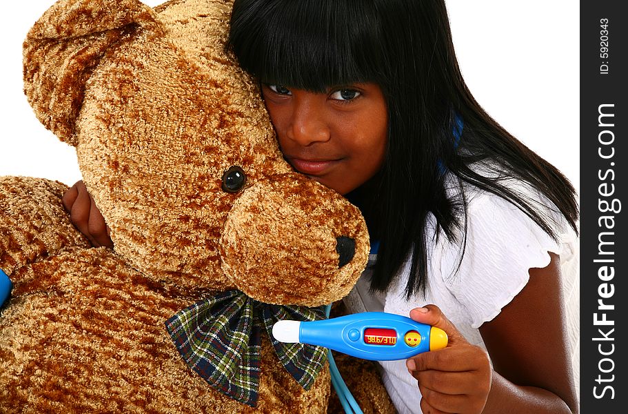 Beautiful 10 year old Indian girl playing doctor to a giant teddy bear. Beautiful 10 year old Indian girl playing doctor to a giant teddy bear.