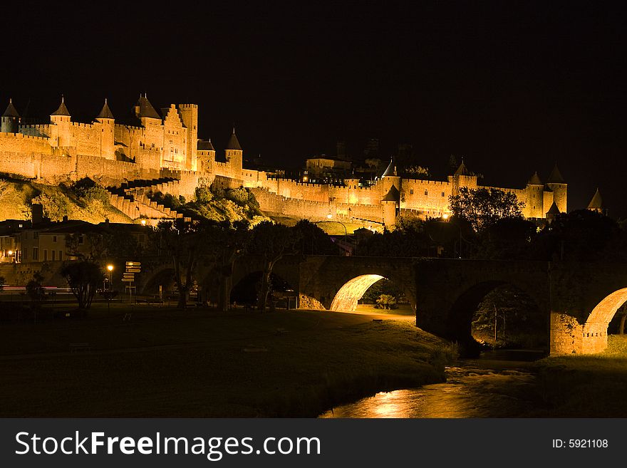 In old Carcassonne, the walls of the medieval city and the Pont Vieux bridge are illuminated at night. In old Carcassonne, the walls of the medieval city and the Pont Vieux bridge are illuminated at night.