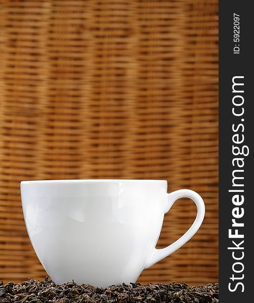 White tea cup on a bed of tea leaves with copy space. White tea cup on a bed of tea leaves with copy space.